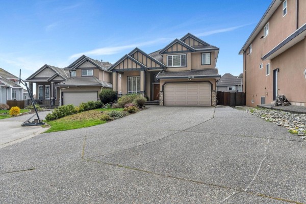 Covered deck with glass railings, metal table, and four chairs overlooking suburban backyards. - 16488 104a Avenue, Surrey