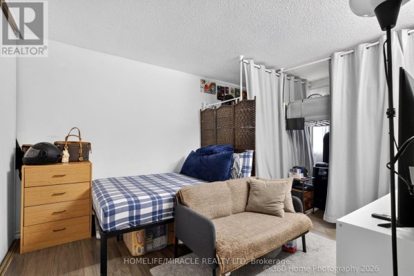 Bedroom with a twin bed, dresser, sofa, and curtains separating a bunk bed area. - 165 - 74 Springfair Avenue, Aurora