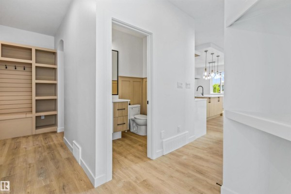 Walk-in closet with white shelves and a clothing rod, offering ample storage space. - 165 Elliott Wd, Fort Saskatchewan
