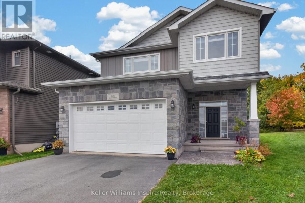 Close-up of the modern house exterior, showing grey siding, stone accents, and a black front door. - 165 Islandview Drive, Loyalist