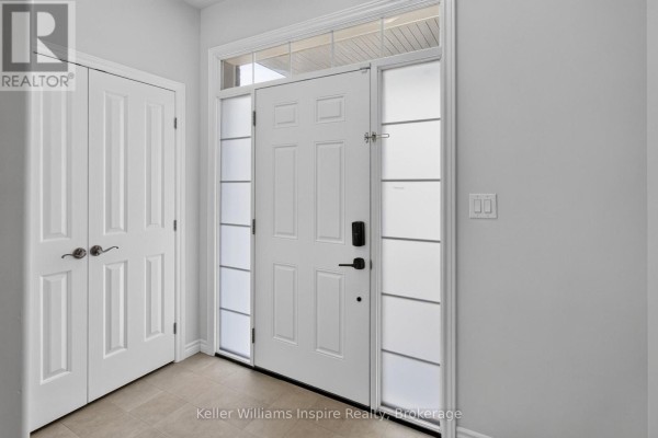 Interior view of the white front door with frosted glass sidelights and a closet with double doors. - 165 Islandview Drive, Loyalist