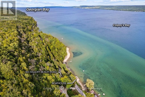 Expansive aerial view showcasing Georgian Bay and Colpoy's Bay, with 165 Mallory Beach Road and boathouse visible along the shoreline. - 165 Mallory Beach Road, South Bruce Peninsula