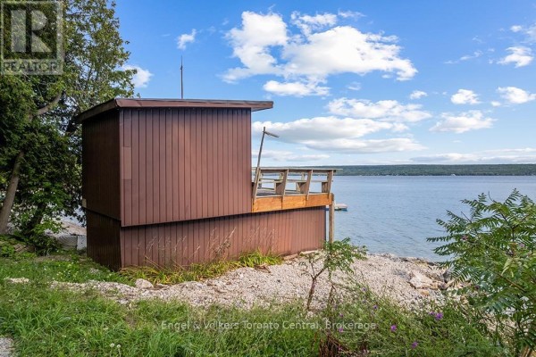Brown wooden structure with deck and lake view - 165 Mallory Beach Road South Bruce Peninsula