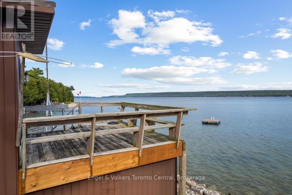 Wooden deck with waterfront view of lake and small floating dock - 165 Mallory Beach Road South Bruce Peninsula