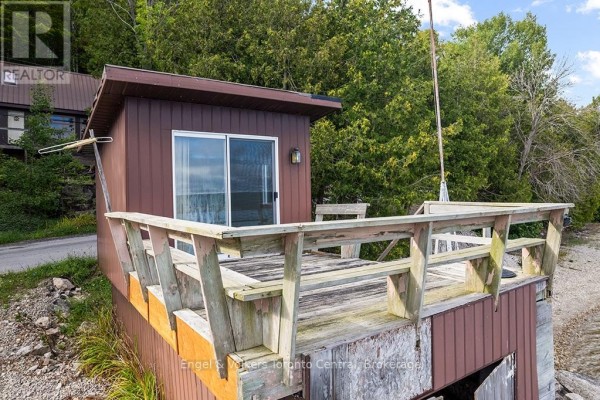 Weathered wooden deck with built-in seating and sliding glass door - 165 Mallory Beach Road South Bruce Peninsula