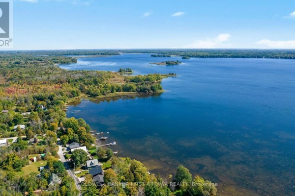 Aerial view of homes along a lake with trees and water. - 165 Rideau Street, Drummond/north Elmsley