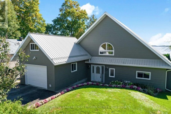 Grey vinyl siding home with a metal roof and attached garage. - 165 Rideau Street, Drummond/north Elmsley