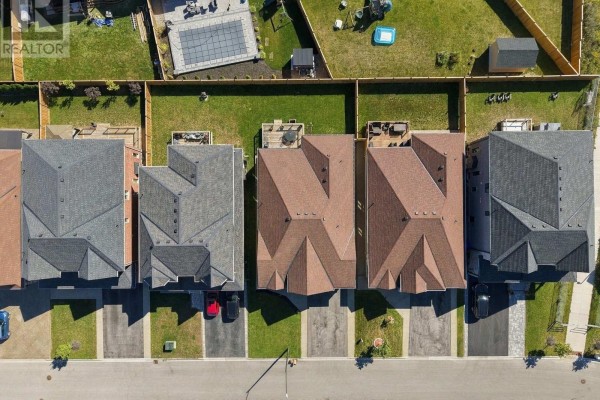 Rear aerial view of 1650 Rizzardo Crescent, Innisfil, highlighting the brick exterior, backyard decks, and green lawn. - 1650 Rizzardo Crescent, Innisfil