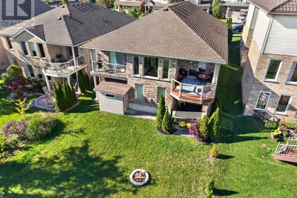 Aerial view of the bungalow's front, highlighting the roofline and surrounding landscaping. - 1653 Cedarcreek Crescent, London North