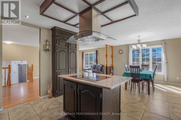 A view from the kitchen shows a dining area and living room with hardwood floors and windows. - 1658 600 Route W, The Nation