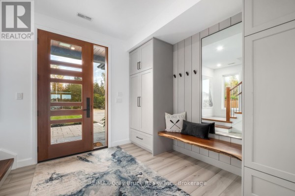 Interior view of a foyer with built-in cabinets, a live-edge wood bench, and a large mirror. - 166 Country Side Drive, Chatsworth