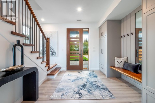 Interior view of a foyer with a wooden staircase, a console table, built-in cabinets, and a bench. - 166 Country Side Drive, Chatsworth