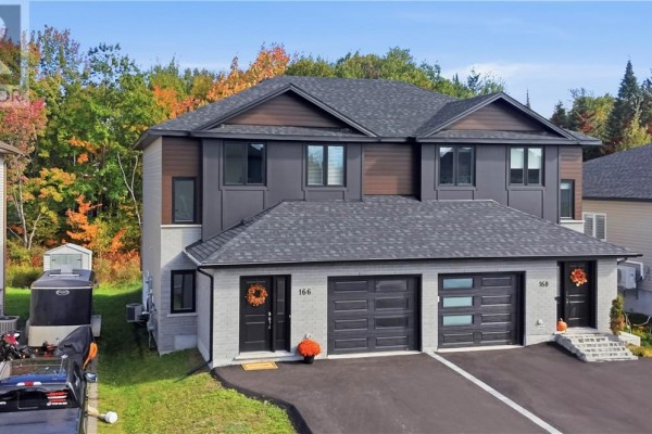 Aerial view of a townhouse complex with autumn foliage in the background. - 166 Eclipse Crescent, Sudbury