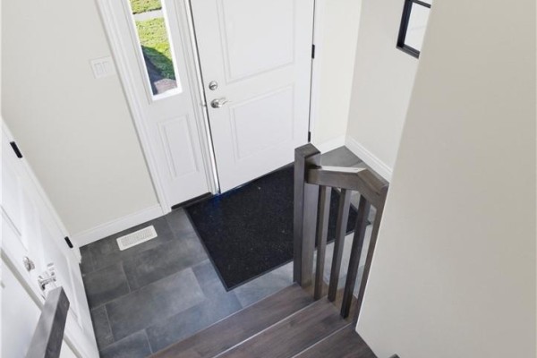 Interior view of the entryway with tile floor and a wooden staircase. - 166 Eclipse Crescent, Sudbury