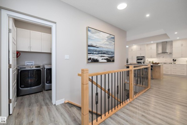 A large walk-in closet with built-in shelving and hanging racks for clothes. - 166 Edgewater Ci, Leduc