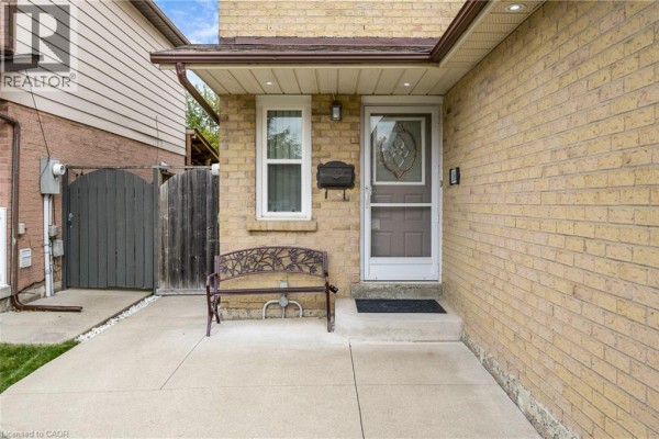 Entrance to a house with a brick walkway, bench, and glass-paned front door. - 166 Martindale Crescent, Brampton