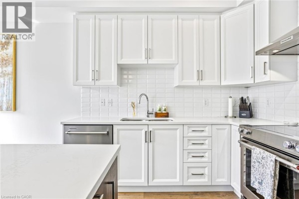 White kitchen cabinets with subway tile backsplash and stainless steel appliances. - 166 Mount Albion Road Unit# 25, Hamilton