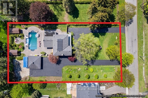 Long asphalt driveway leading to a grey house with a large tree and fountain. - 1663 5th Avenue E, Owen Sound