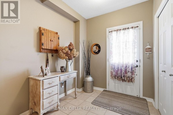 Foyer with a white door, a vintage desk, a floor vase, and tiled floor. - 1667 Manon Street, Clarence Rockland