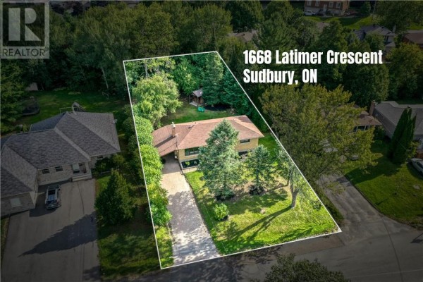 Aerial drone view of 1668 Latimer Crescent, a residential property surrounded by trees. - 1668 Latimer Crescent, Sudbury