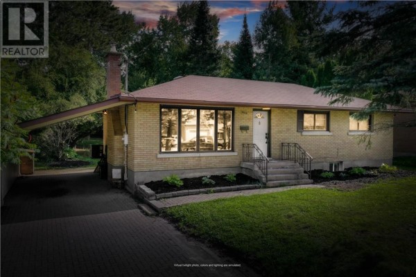 Front exterior of a brick bungalow at dusk with interior lights illuminated. - 1668 Latimer Crescent, Sudbury