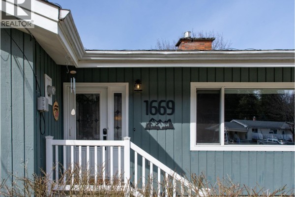 Close-up of the house entrance with the address number 1669 and a mountain-themed decoration. - 1669 Hiob Road, Revelstoke