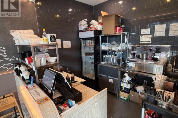 Restaurant kitchen area with shelving, a refrigerator, and a stainless steel prep station. - 167 - 390 Silver Star Boulevard, Toronto