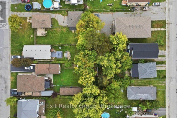 Aerial view of a residential street with multiple houses and mature trees. - 167 Marmora Street, Quinte West