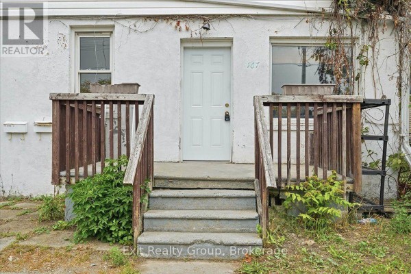 Close-up of the front entrance with concrete steps and a white door. - 167 Marmora Street, Quinte West