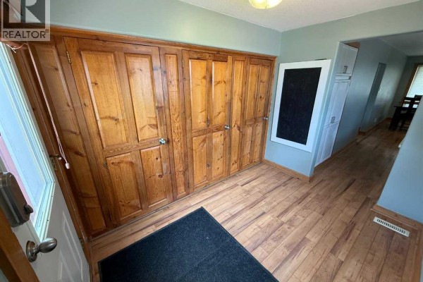 Kitchen with white cabinetry, stainless steel appliances, and a double sink with a window above. - 167 Sunwapta Drive, Hinton