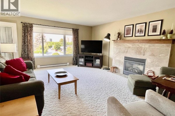 Dining room with a wooden table, chairs, carpet, and a view into the kitchen. - 1672 Thayer Court, Kelowna