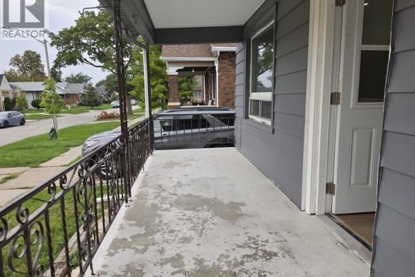View from the porch looking down the street with a car parked on the lawn. - 1674 Hickory Road Unit# Main, Windsor