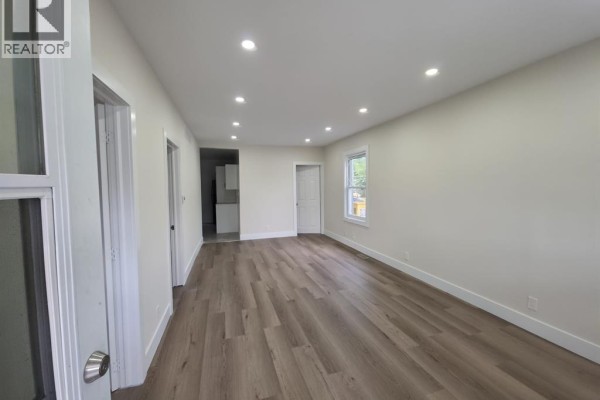 Living room with light grey walls, wood laminate flooring, and recessed lighting. - 1674 Hickory Road Unit# Main, Windsor
