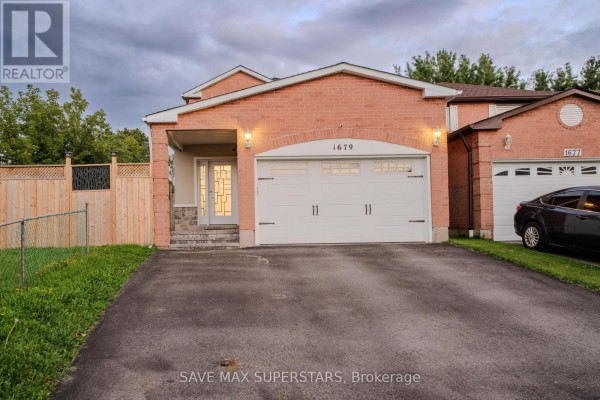 The front of the house shows a double garage, an arched entryway, and a paved driveway. - 1679 Portland Court, Pickering