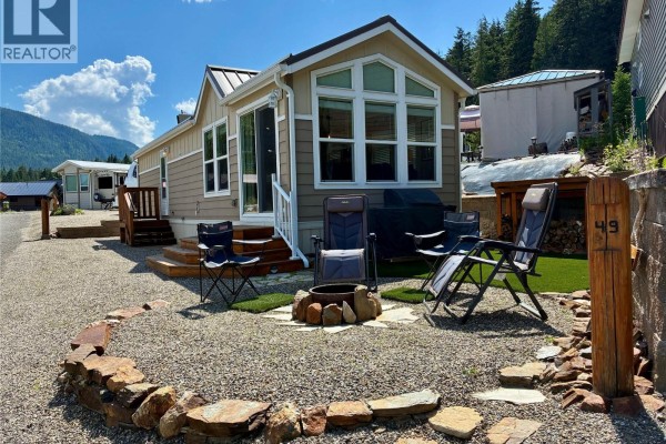 Boat launch and docks on a serene lake with mountain backdrop. - 1681 Sugar Lake Road Unit# 49, Cherryville