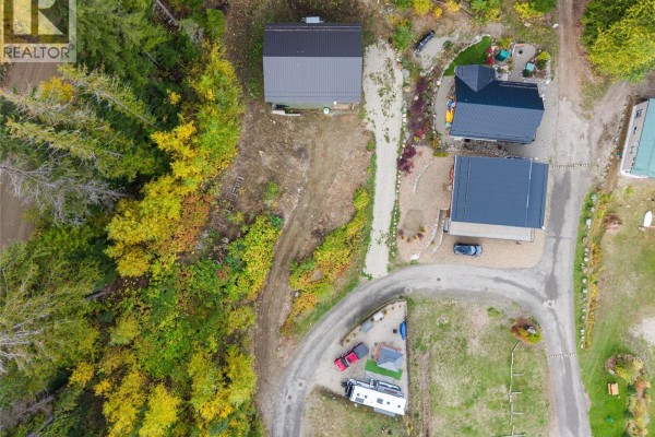 Top-down aerial view of multiple structures on a wooded property with a winding driveway. - 1681 Sugar Lake Road Unit# 62, Cherryville
