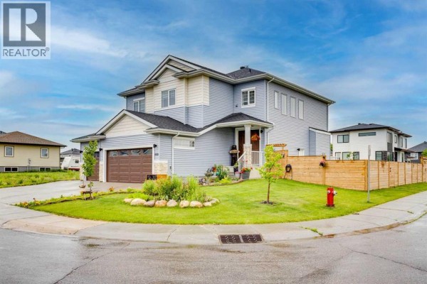 Side exterior of the house showing a pitched roof, siding, and a fenced backyard. - 169 Beaveridge Close, Fort Mcmurray