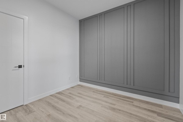 Room under renovation with decorative wall panels, a tray ceiling, and two doorways. - 169 Elliott Wd, Fort Saskatchewan