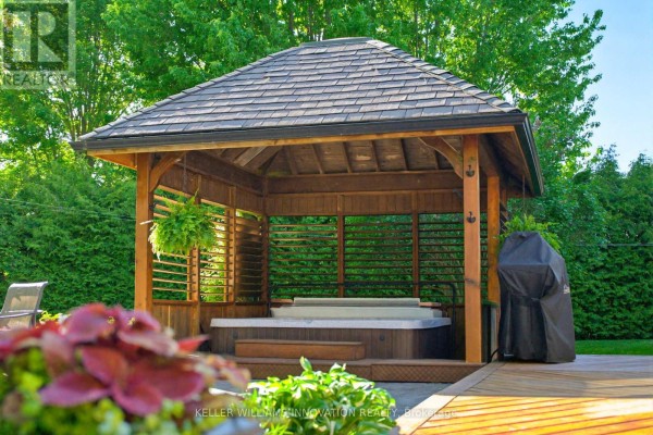 Wooden gazebo with a hot tub, surrounded by greenery and a barbecue on the right. - 169 James Street, North Perth