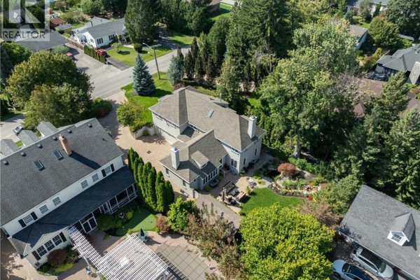 Aerial view of the rear of the property, showing a backyard with landscaping and neighboring homes. - 169 John Street W, Niagara On The Lake