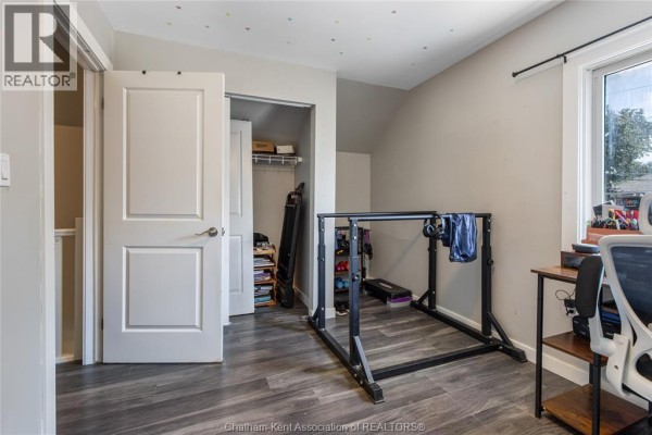 Weight rack, treadmill, desk, and office chair in a room - 169 Lorne Avenue Chatham