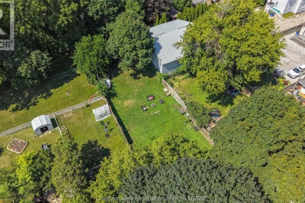 Large fenced yard with shed, detached garage, fire pit, and seating - 169 Lorne Avenue Chatham