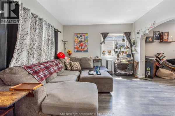 Sectional sofa, Mickey Mouse art, and plants in living room - 169 Lorne Avenue Chatham