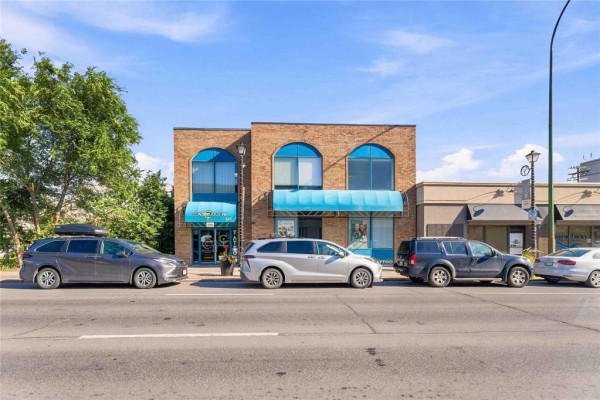 Street view of the commercial building at 169 Marion Street with cars parked out front. - 169 Marion Street, Winnipeg