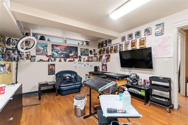 Tattoo studio with black leather armchair, tattoo beds, and numerous framed art on walls. - 169 Marion Street, Winnipeg
