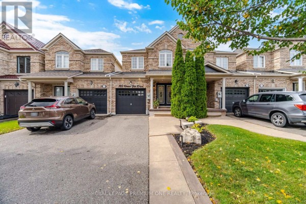 Front view of a brick townhouse with a garage and driveway. - 169 Venice Gate Drive, Vaughan