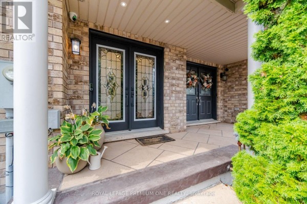 Close-up of a covered front porch with double glass doors and potted plants. - 169 Venice Gate Drive, Vaughan