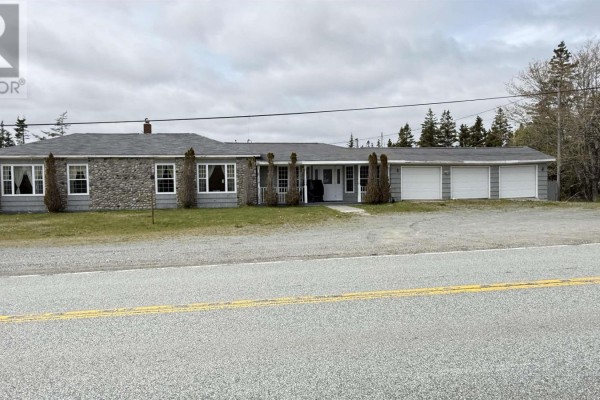 Large room with carpet, a wood stove, and glass double doors. - 16989 Highway 7, Pleasant Harbour