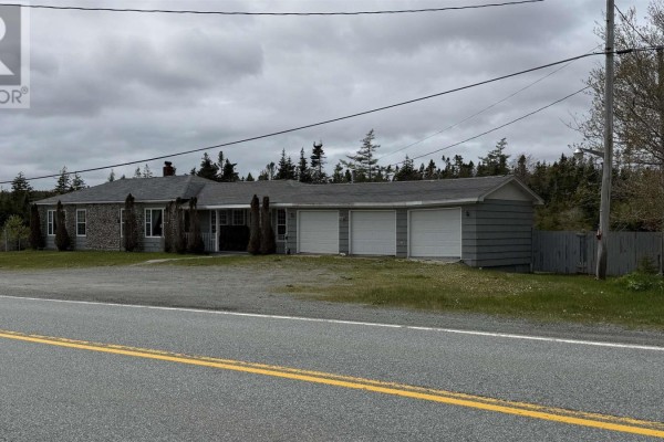 Exterior view of a two-car garage with white doors and a separate storage shed. - 16989 Highway 7, Pleasant Harbour
