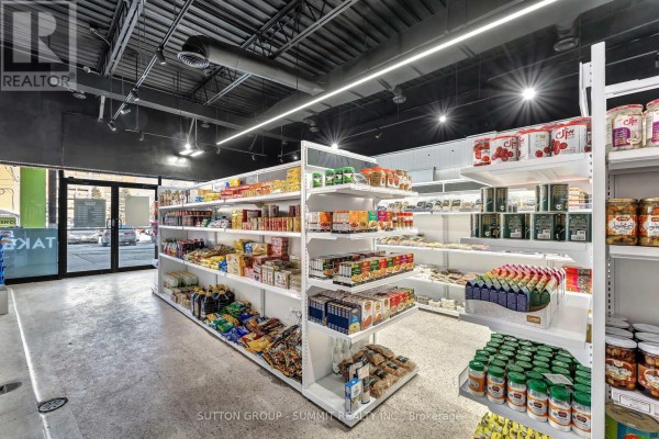 Aisle of white retail shelves displaying packaged food items, jars, and boxes in a market. - 17 - 2500 Hurontario Street, Mississauga